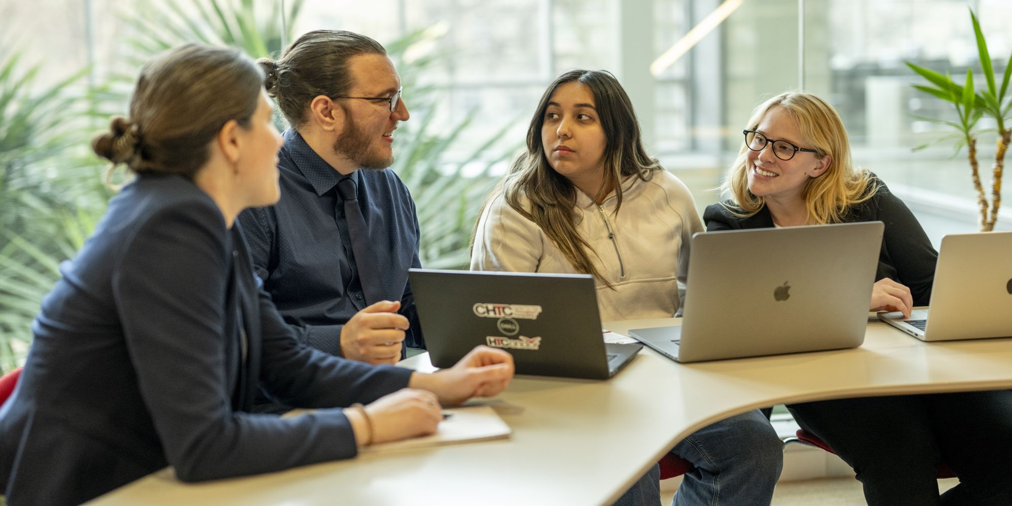 Researchers gathered with laptops, collaborating in a casual setting